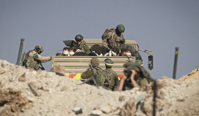 Israeli soldiers detain blindfolded Palestinian men in a military truck in the Zeitoun district of the southern part of the Gaza Strip on November 19, 2023. (AFP file photo)