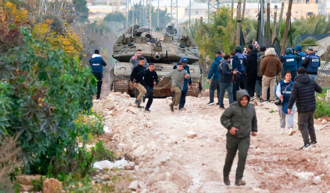 Palestinian children and journalists disperse as Israeli tanks enter the Jenin camp for Palestinian refugees in the occupied West Bank, on February 23, 2025. (AFP)