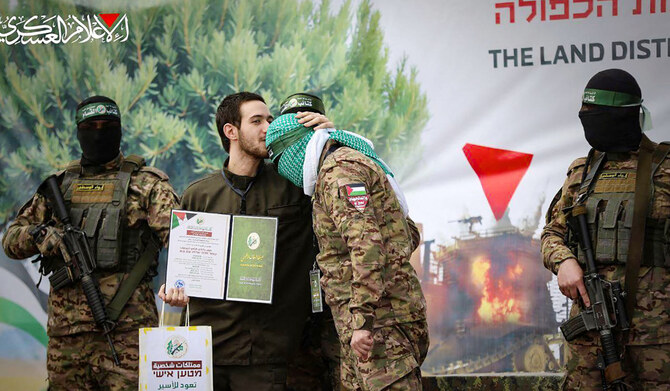 This handout image released by the Hamas Media Office on February 22, 2025, shows newly-released Israeli hostage Omer Shem Tov kissing the head of a Hamas fighter shortly after being set free in Nuseirat in the central Gaza Strip. (AFP)