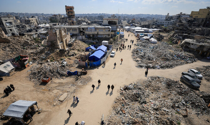 Palestinians walk near the rubble of buildings, amid a ceasefire between Israel and Hamas, in Gaza City, February 26, 2025. (Reuters)