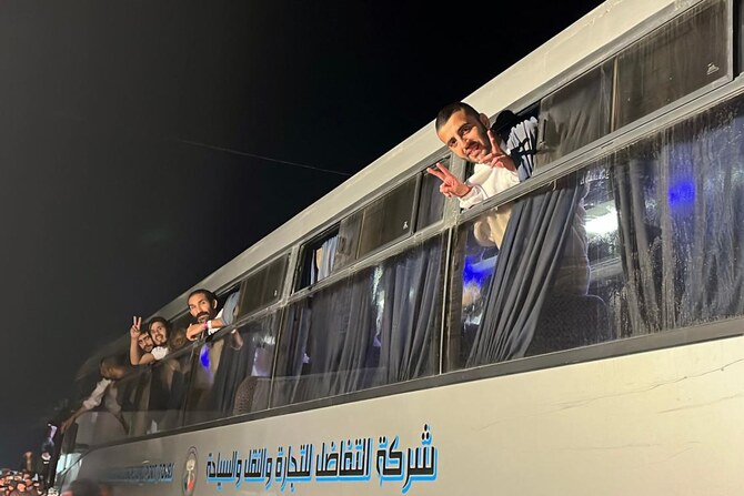 Palestinians, released by Israel, gesture as they arrive on a bus at the European Hospital in Khan Yunis in the southern Gaza Strip early on February 27, 2025. Hamas handed over the coffins of four hostages early on February 27, Israeli authorities confirmed, followed soon after by the return of hundreds of freed Palestinian prisoners to the West Bank and Gaza.(AFP)