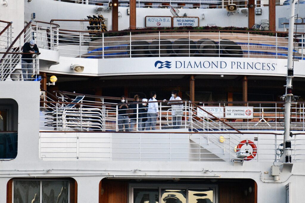 This picture taken on February 24, 2020 shows crew members aboard the Diamond Princess cruise ship at the Daikoku Pier Cruise Terminal in Yokohama port. (AFP)
