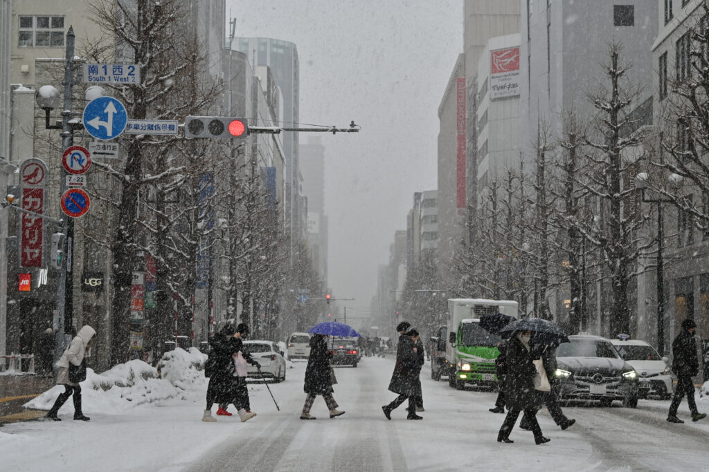 Pedestrians crossing the street in the snow in central Sapporo, Hokkaido. (AFP)
