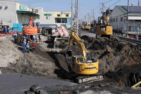 Excavators and rescue personnel working to construct a slope for rescue operations are seen at the site where a truck on January 28 plunged into a sinkhole, trapping the vehicle's driver, in Yashio, Saitama Prefecture on February 1, 2025. (AFP)