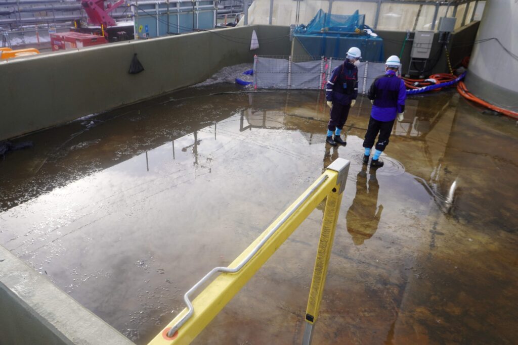 This handout photo taken and released on March 4, 2025 from Tokyo Electric Power Company (TEPCO) shows employees after the removal of the first tank in the J9 area during progress with the dismantling of the tanks at TEPCO's Fukushima Daiichi nuclear power plant in Okuma, Fukushima prefecture. (AFP)