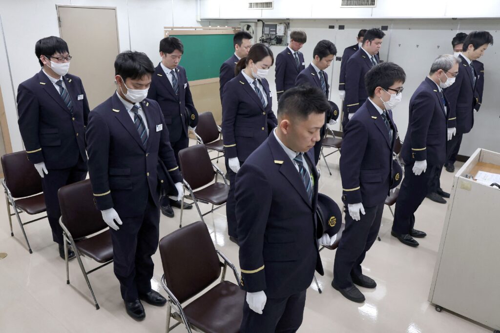 Employees of Tokyo Metro observe a moment of silence in the office at Kasumigaseki Station to mark 30 years since the Tokyo subway sarin gas attack in Tokyo on March 20, 2025. (AFP)