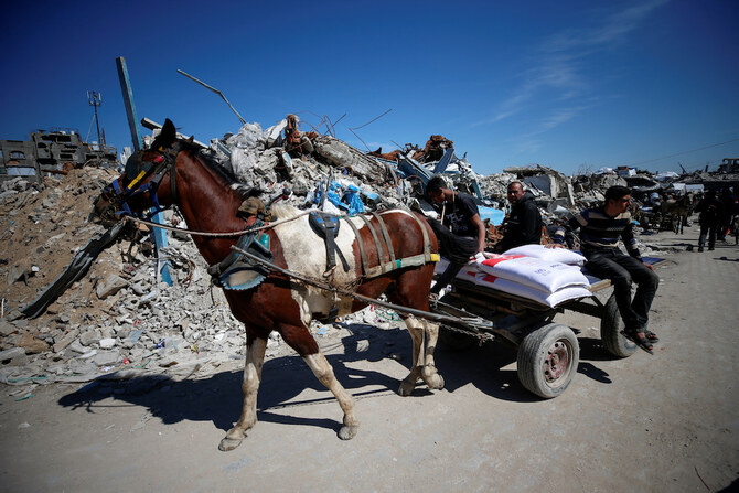 Palestinians transport aid provided by UNRWA including food supplies, on a horse-drawn cart, after Israel says it has ceased entry of humanitarian aid into Gaza, at Jabalia refugee camp in northern Gaza Strip, March 2. (Reuters)