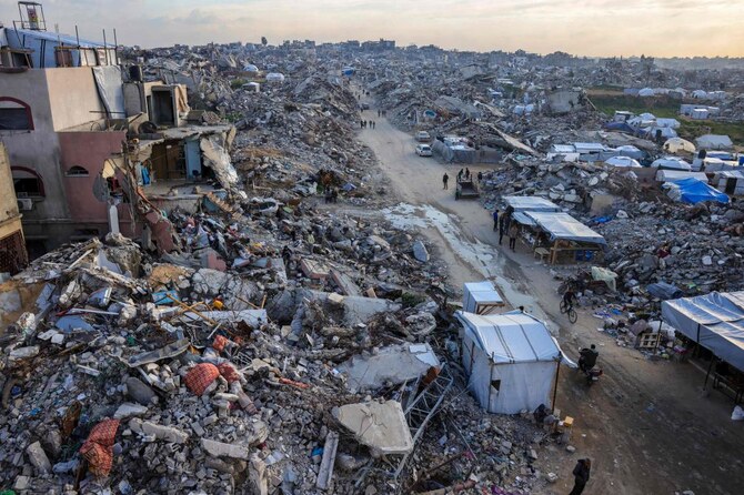 Palestinians walk amid the rubble of buildings in Beit Lahia in the northern Gaza Strip on Mar. 4, 2025. (AFP)