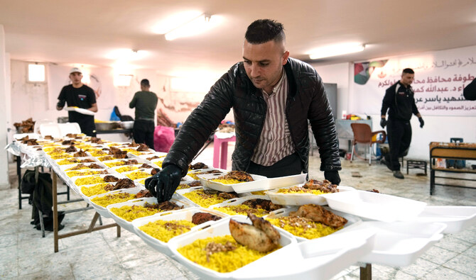 Volunteers at the Yasser Arafat Charity Kitchen in Tulkarm, West Bank, prepare an iftar meal for displaced Palestinians. (File/AP)