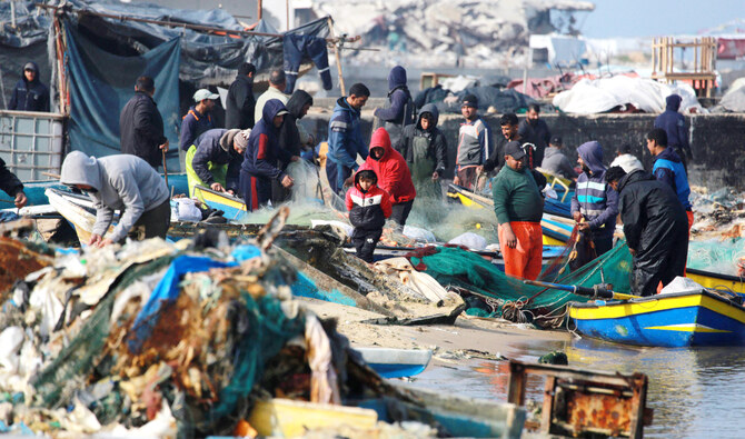 Palestinian fishermen gather at the port of Gaza City. Israeli bombardment has destroyed most of the boats in the harbor, wrecking their means of making a living. (AFP)