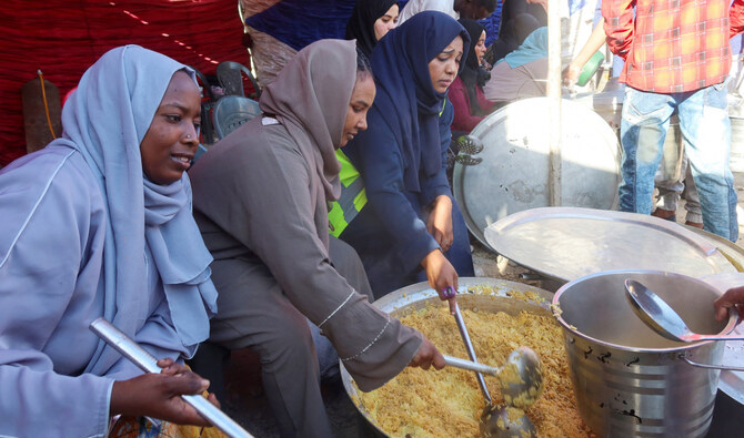Displaced people and volunteers from local charity Al-Hawadith Street Initiative prepare food to break their fast, before Iftar in the city of Port Sudan. (Reuters)