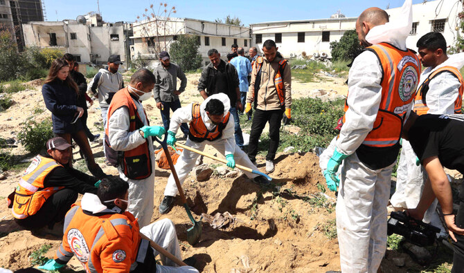 Palestinian civil defense workers uncover corpses buried in the grounds of the Al-Shifa Hospital in Gaza City on Thursday. (AFP)