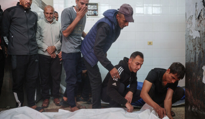 Relatives mourn by the body of a Palestinian man who was killed in an Israeli drone strike east of the Bureij camp, at the al-Aqsa Martyrs hospital morgue in Deir el-Balah in the central Gaza Strip on March 17, 2025. (AFP)