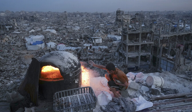Palestinians Ali Marouf cook on fire on the roof of his destroyed house by the Israeli army's air and ground offensive in Jabaliya, Gaza Strip, on Monday, March 17, 2025. (AP)