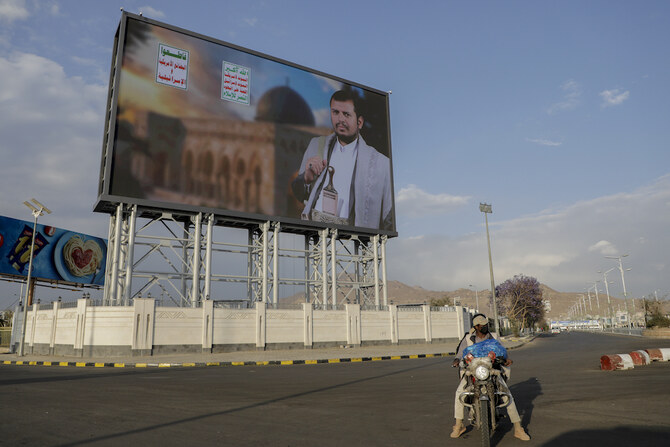 Yemenis pass under a street billboard displaying a picture of Abdul Malik Al-Houthi, the leader of the Houthi movement, in Sanaa, Yemen, Tuesday, March 18, 2025. Arabic reads, “death to America, death to Israel.” (AP)