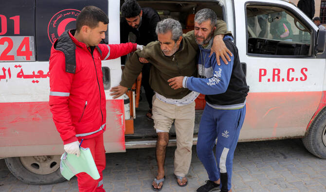 Paramedics assist an injured Palestinian to exit an ambulance upon arrival at the Indonesian Hospital in Beit Lahia in the northern Gaza Strip. (File/AFP)