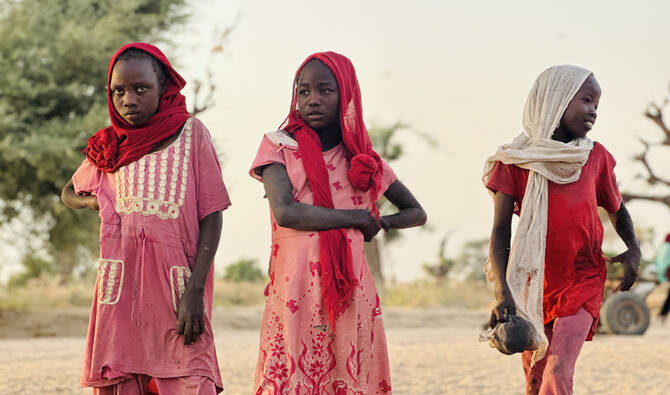 Displaced Sudanese girls, who fled the Zamzam camp, look on as they gather near the town of Tawila in North Darfur on February 14, 2025. (AFP/File)
