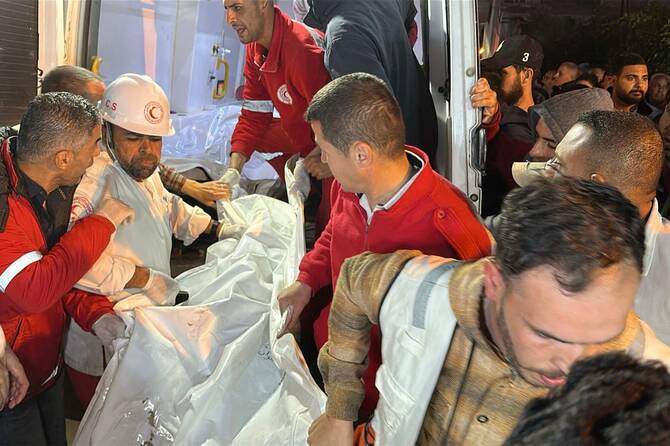 Paramedics transport out of an ambulance some of the bodies of Palestinian first responders, who were killed a week before in Israeli military fire on ambulances, into Nasser Medical Complex in Khan Yunis in Gaza Strip on March 30, 2025. (AFP)