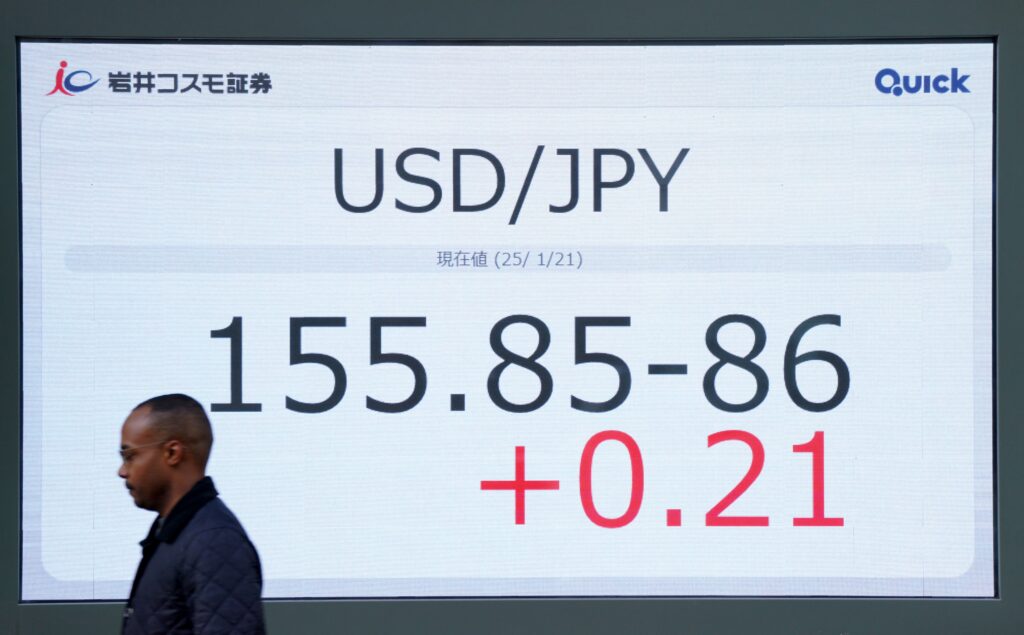 A man walks past an electronic board showing the foreign exchange trading price of the Japanese yen against the US dollar on a street in central Tokyo on January 21, 2025. (AFP)