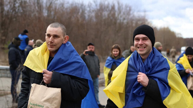 Some of the 175 Ukrainian prisoners of war wrapped with national flags, following an exchange at an undisclosed location, amid the Russian invasion in Ukraine, Mar. 19, 2025. (AFP)