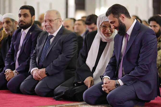 Syria's interim President Ahmed Al-Sharaa (R) listening to the country's new Grand Mufti Sheikh Osama Al-Rifai (2nd R) during the the Eid Al-Fitr morning prayer in Damascus on March 31. (AFP)