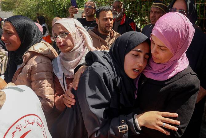 Relatives mourn during the funeral procession for members of the Palestine Red Crescent and other emergency services who were killed a week earlier by Israeli forces, at Nasser hospital in Khan Yunis in the southern Gaza Strip on March 31, 2025. (AFP)