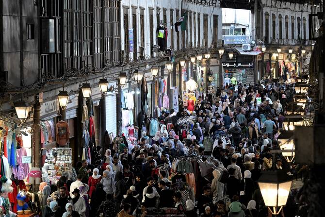 Shoppers walk browsing for items along the alley of Damascus' Hamidiya covered market, Mar. 29, 2025. (AFP)