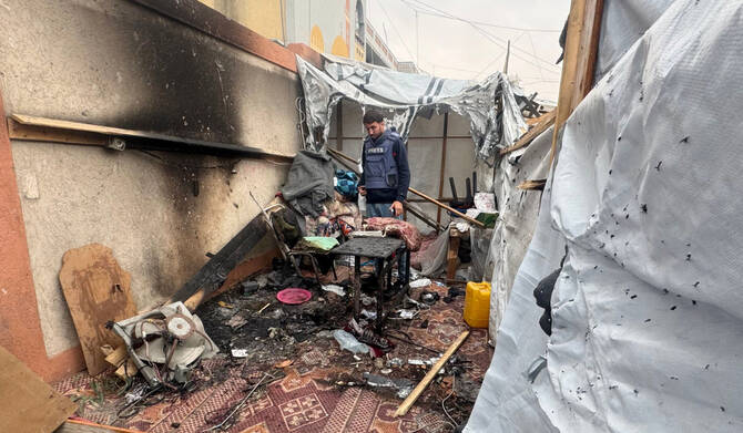 A Palestinian journalist inspects the debris and damage after an Israeli strike hit a tent used by journalists in the southern city of Khan Yunis on April 7, 2025. (AFP)