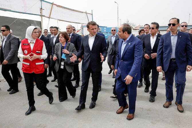 French President Emmanuel Macron (C), Egyptian President Abdel Fattah al-Sisi (3rd R) and Dr Amal Emam, CEO of the Egyptian Red Crescent (2nd L), visit Egyptian Red Crescent warehouses storing aid for Gaza, in the Egyptian border town of El-Arish. (AFP)