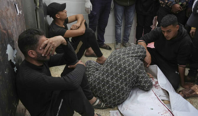 Relatives mourn next to the body of a Palestinian killed in an Israeli airstrike, at the morgue of Al-Aqsa Hospital in Deir al-Balah, central Gaza Strip, Saturday, April 12, 2025. (AP)