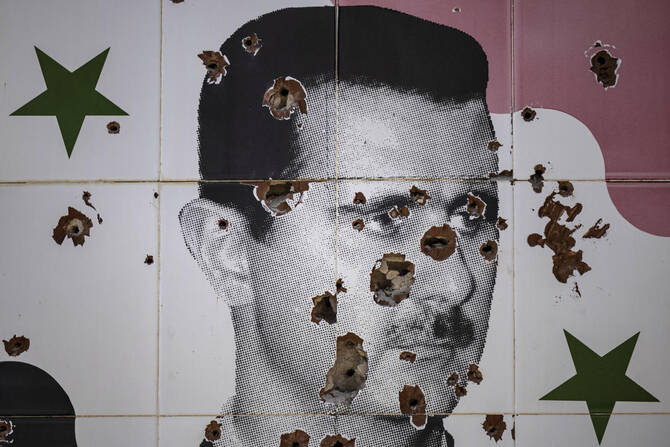 Bullet holes deface a mural depicting the toppled Syrian president Bashar al-Assad in Adra town on the northeastern outskirts of Damascus (AFP)