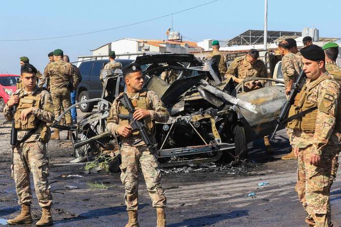 Lebanese soldiers inspect the site near a burnt-out vehicle reportedly hit by an Israeli strike in Ghazieh. (AFP)