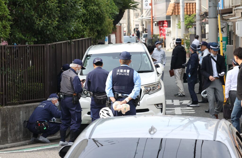 Police officers investigate the scene in Osaka's Nishinari district on May 1, 2025, after a man was arrested after allegedly ploughing his car into seven schoolchildren in a suspected deliberate attack, local media said. (AFP)