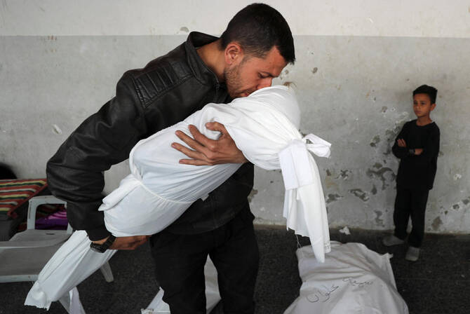 A Palestinian man kisses the body of his nephew Nour Nabhan, 5, who was killed in an Israeli strike, at Al-Ahli Arab Baptist hospital, in Gaza City, May 21, 2025. REUTERS/Mahmoud Issa