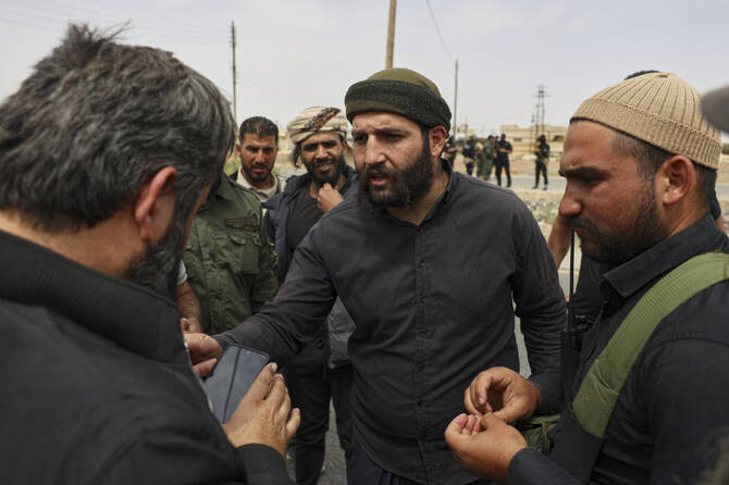 Sheikh Laith al-Balous, centre, a Druze leader in the southern Sweida province, speaks with Sweida governor Mustafa al-Bakour, left, at a highway where they found bodies of Syrian Druze fighters, on Thursday, May 1, 2025. (AP)
