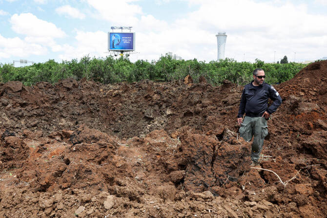 An Israeli police officer investigates a crater at the site of a missile attack, launched from Yemen, near Ben Gurion Airport, in Tel Aviv, Israel, May 4, 2025. (Reuters)