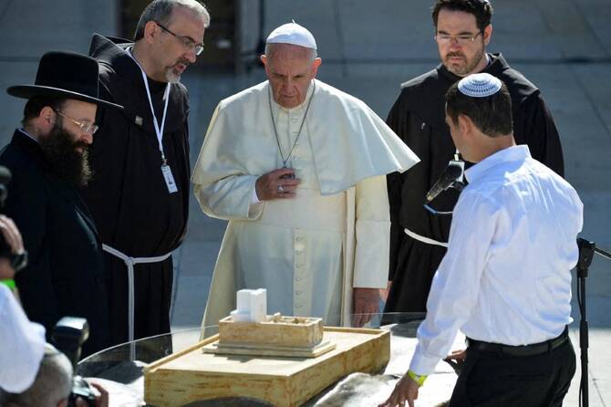 Pope Francis (C) looks at model of the Western Wall square with religious leaders near the Western Wall in Jerusalem’s Old City on May 26, 2014. (AFP)