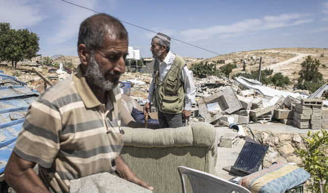 Palestinians stand on the rubble of a demolished building in the village of Khallet Al-Dabaa in the occupied West Bank on May 6, 2025, after Israeli forces destroyed ninety-five percent of all the houses displacing around one hundred people. (AFP)