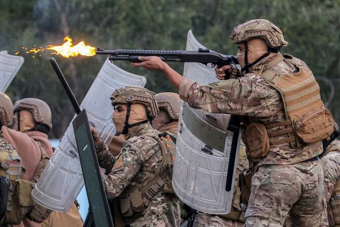 A member of the Lebanese Army riot-control forces fires a shotgun as they try to disperse a Hezbollah-organised rally to block the road to Beirut International Airport over a decision to bar two Iranian flights from landing there, in Beirut, Feb. 15, 2025. (AFP)