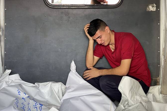 A Palestinian man mourns by bodies of casualties of Israeli strikes in the back of a vehicle ahead of burial, at the Nasser hospital in Khan Yunis in the southern Gaza Strip, May 15, 2025. (AFP)