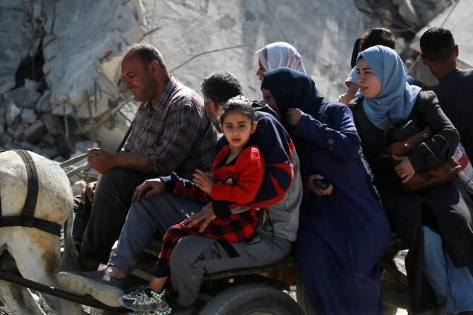 Palestinians ride an animal-pulled cart as they flee Gaza City on May 16, 2025. (File/AFP)
