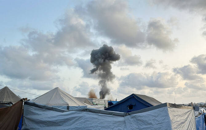 Smoke rises following Israeli strikes, as seen from a tent camp sheltering displaced Palestinians, in Khan Younis, southern Gaza Strip, May 19, 2025. (Reuters)