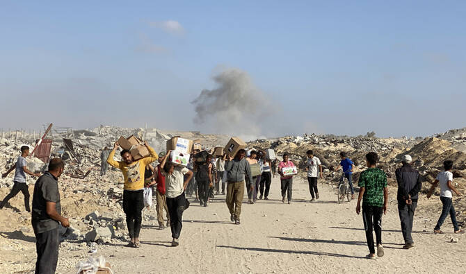 Displaced Palestinians receive food packages from a US-backed foundation pledging to distribute humanitarian aid in western Rafah in the southern Gaza Strip on May 27, 2025. (AFP)