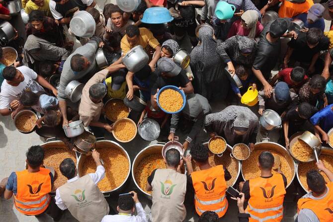 Palestinians queue for a hot meal at a charity kitchen in Gaza City on Apr. 30, 2025. (AFP)