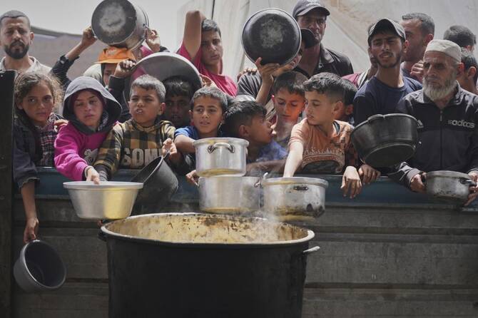 Palestinians wait to get food at a community kitchen in Khan Younis, in southern Gaza Strip, Apr. 24, 2025. (AP)