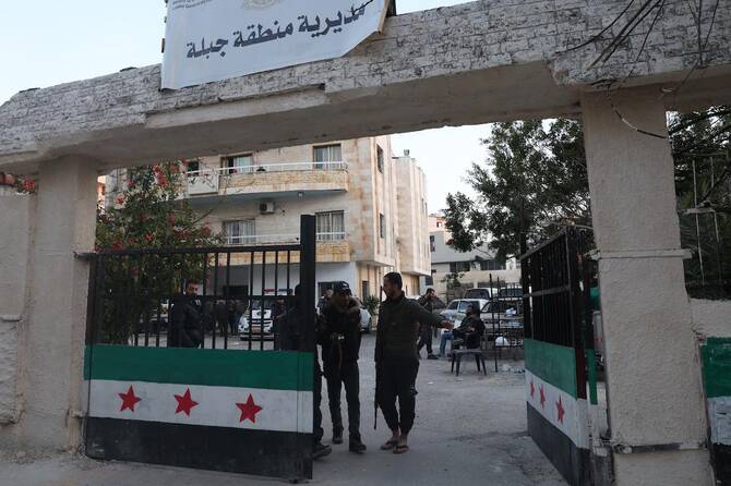Security forces with Syria's new government gather in the municipality building in the town of Jableh in the coastal province of Latakia. (File/AFP)