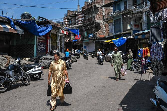People walk through the market near a bus station in the main town of Poonch district in Jammu region on May 11, 2025. (AFP)