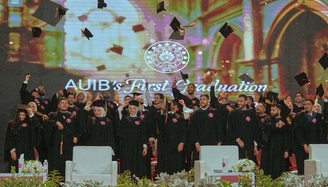 The American University of Iraq - Baghdad graduates throw their mortarboards into the air during the first graduation for the school in Baghdad, Iraq, Saturday, May 24, 2025. (AP)