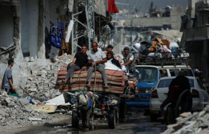 Palestinians ride a cart with belongings as they flee their homes, after Israeli air strikes, in the northern Gaza Strip May 17, 2025. (Reuters)