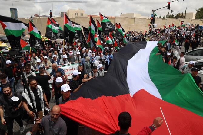 Palestinians wave national flags as they take part in a rally to commemorate the 77th anniversary of the Nakba in the city of Ramallah in the occupied West Bank, May 14, 2025. (AFP)